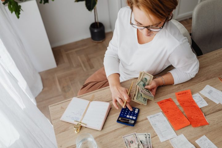 Mulher calculando gastos pessoais no escritório da casa