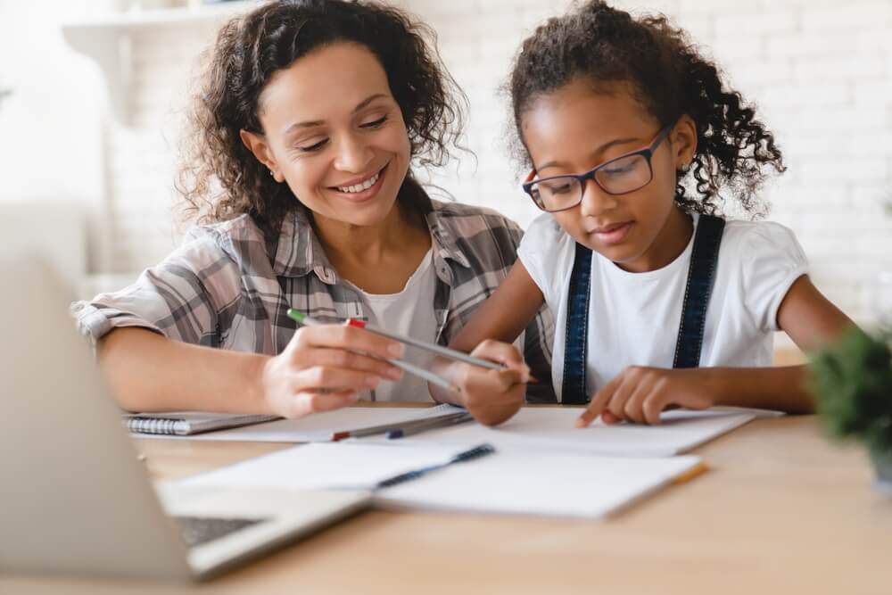 Imagem de uma mulher dando aulas particulares para uma criança como forma de fazer renda extra.